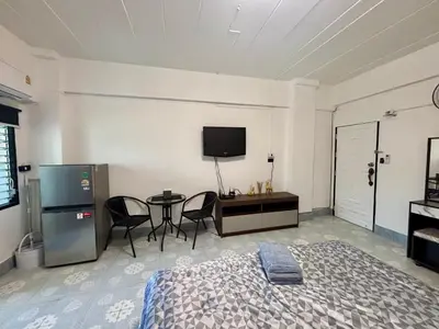 a bedroom with a bed and a table and a tv at Kimchi Apartment in Patong Beach