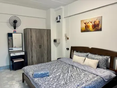 a bedroom with a bed and a mirror in it at Kimchi Apartment in Patong Beach