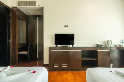 a room with two beds and a flat screen tv at Yenna Apartment in Kamala Beach