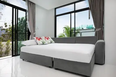 a large bed in a room with windows at Namara The Residences A in Kamala Beach