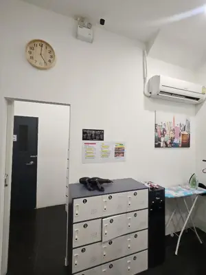 a room with a dresser and a clock on the wall at TJ Patong HOSTEL in Patong Beach