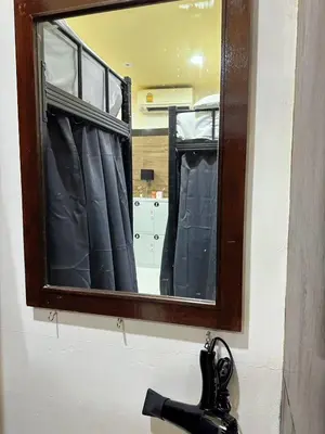 a mirror on a wall above a bathroom sink at TJ Patong HOSTEL in Patong Beach