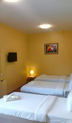 a hotel room with three beds and a tv at I Talay phuket in Karon Beach