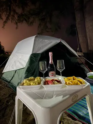 a table with two glasses and a bottle of wine at TENT Maikhao in Ban Mai Salae