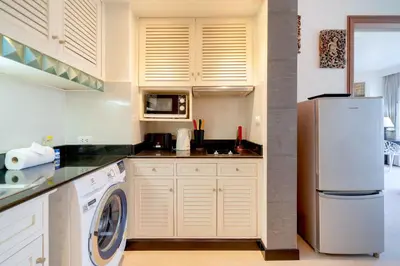 a kitchen with a white refrigerator and a dishwasher at Allamanda Premium Apartments Laguna Phuket in Laguna Phuket