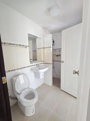 a white bathroom with a toilet and a sink at MB Home in Ban Bang Khu
