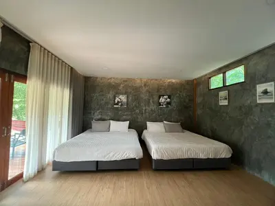 a bedroom with two beds and a window at maksaihomestay in Ban Lo Pa Ret