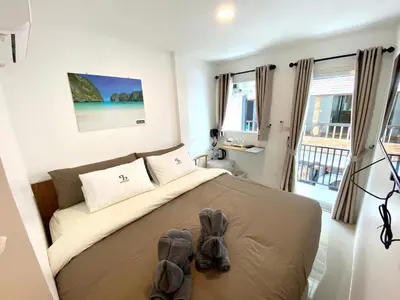 a bedroom with a bed with a pair of shoes on it at SJ Beach House Patong in Patong Beach