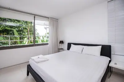 a white bedroom with a large bed and a window at Private 3-Storey Pool Villa Atika 10, for 7, views of Patong Bay in Patong Beach