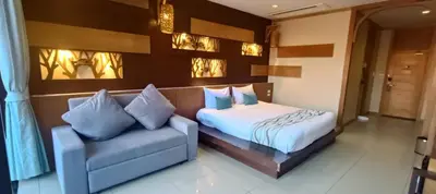 a bedroom with a bed and a couch at โรงแรมชาวเกาะพีพี Chaokoh Phi Phi Island in Phi Phi Don