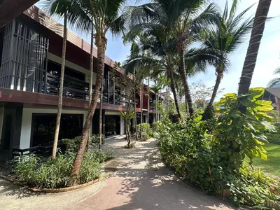 a building with palm trees in front of it at โรงแรมชาวเกาะพีพี Chaokoh Phi Phi Island in Phi Phi Don