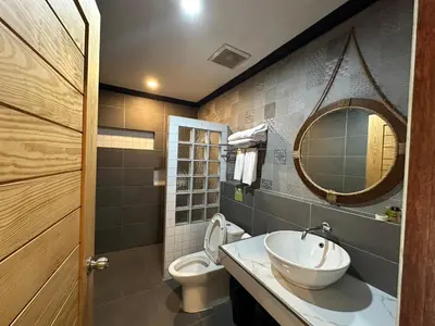 a bathroom with a sink and a toilet and a mirror at โรงแรมชาวเกาะพีพี Chaokoh Phi Phi Island in Phi Phi Don