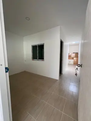 an empty room with white walls and a wooden floor at Tim House Thalang Phuket 1 in Thalang