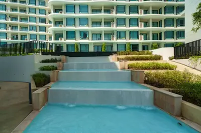 a swimming pool with stairs in front of a building at Amazing View Duplex La Vita in Phuket Town