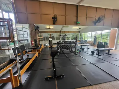 a gym with a lot of equipment and people in it at Casa Sakhu Beach Villa Phuket in Nai Yang Beach