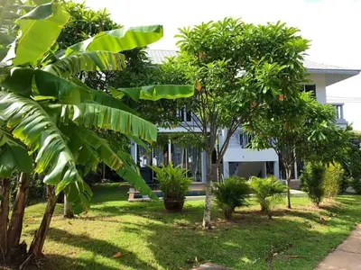 a house with palm trees in the yard at Casa Sakhu Beach Villa Phuket in Nai Yang Beach