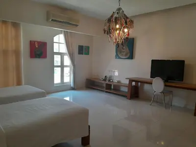 a bedroom with a bed and a desk and a television at Pimnara Boutique Hotel By Simply Serene in Patong Beach