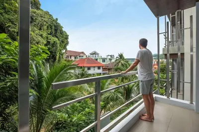 a man standing on a balcony looking out at the city at 4BR Villa B5 with Pool, Vibrant Life at Kata Beach - UTK5 in Kata Beach