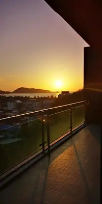 a view of the sunset from the balcony of a building at Emerald Terrace Resort 2 bedrooms Panoramic Ocean View Top Floor in Patong Beach
