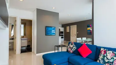 a living room with a blue couch and a kitchen at Apartment 2 bedrooms on Kamala in Phuket Town