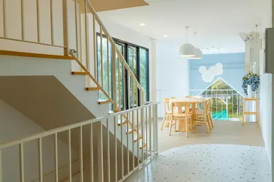a staircase in a house with a table and chairs at Sea Side at Ao Nang Landmark Night Market Krabi in Ban Khlong Haeng