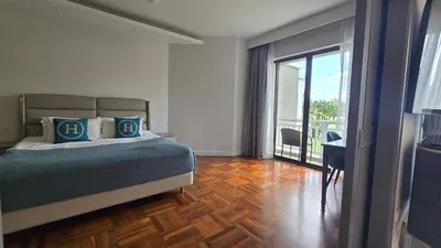 a hotel room with a bed and a balcony at Allamanda Laguna in Laguna Phuket