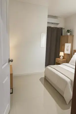 a white bedroom with a bed and a window at CİMELi Guest House in Patong Beach