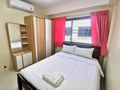 a bedroom with a large white bed with a window at Kata beach Townhouse BL2 in Kata Beach