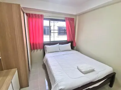 a bed in a room with a red window at Kata beach Townhouse BL2 in Kata Beach