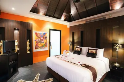 a bedroom with a large bed with orange walls at 06 - Luxurious & Lavish Getaway in Surin Beach in Surin Beach