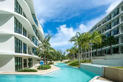 a swimming pool in front of a building at 2 bedrooms apartment La Vita Rawai in Rawai Beach