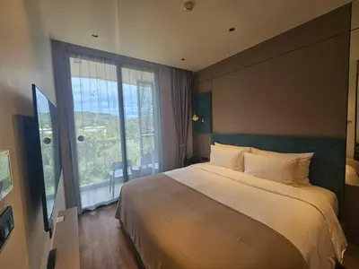 a bedroom with a large bed and a large window at Modern apartment Layan Beach in Layan Beach