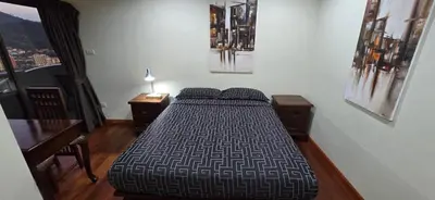 a bedroom with a bed and a desk with a lamp at PATONG TOWER Big Family APARTMENTs 2026 Pta in Patong Beach