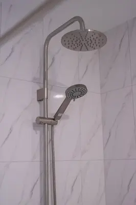 a shower with two shower heads in a bathroom at Baan Chom View Residences in Kamala Beach