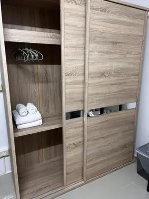 a wooden wardrobe with wooden doors in a room at Sleepwell at naiyang No2 in Nai Yang Beach