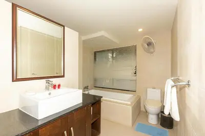 a bathroom with a sink and a tub and a toilet at Naiharn beach sands Apartment in Nai Harn Beach