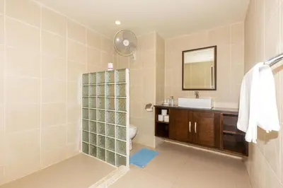 a bathroom with a sink and a toilet and a mirror at Naiharn beach sands Apartment in Nai Harn Beach