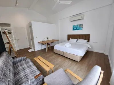 a bedroom with a bed and a couch and a table at Zen House Mono in Ban Na Bon