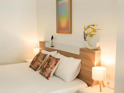 a bedroom with a bed with pillows on it at Place Hotel in Kata Beach