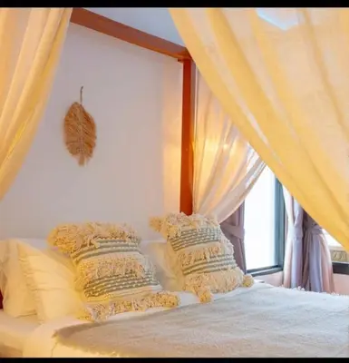 a bedroom with a bed with pillows and a window at The beach house in Surin Beach