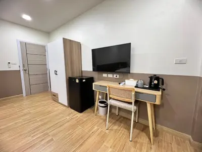 a hotel room with a desk and a television at Kata walk&wave hostel in Kata Beach