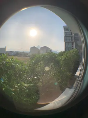 a view of a building from a window with a tree at Cozy condo in Ban Tha Khreng