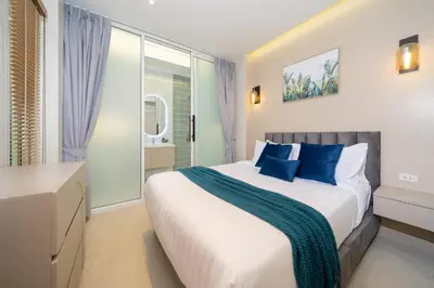 a bedroom with a large bed with blue pillows at Patong private pool Villa 5BR 4Bath in Patong Beach