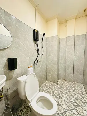 a bathroom with a toilet and a phone on the wall at Dedbaicha cafe & Hostel Phuket old town in Phuket Town
