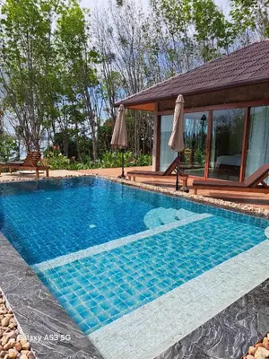 a swimming pool in front of a house at Bulan Villa Koh Yao Noi in Ban Laem Sai