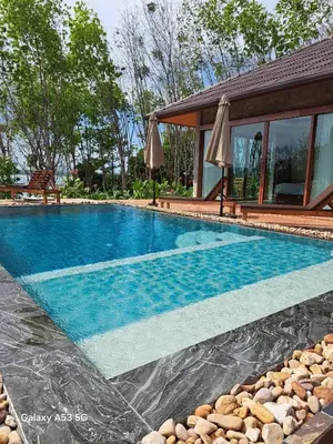 a swimming pool in front of a house at Bulan Villa Koh Yao Noi in Ban Laem Sai