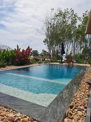 a swimming pool with blue water in a yard at Bulan Villa Koh Yao Noi in Ban Laem Sai