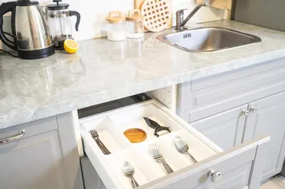 a kitchen drawer with utensils in it next to a sink at Lovely Vlada in Nai Yang Beach
