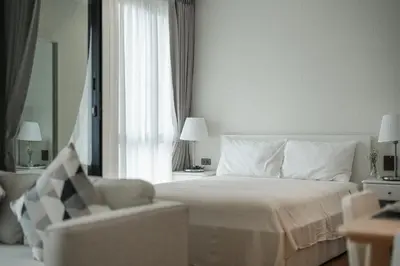 a bedroom with a bed and a chair and a window at Квартира в The Title Halo 1 in Nai Yang Beach