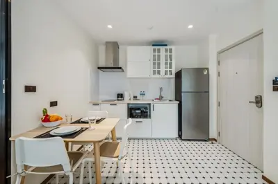 a kitchen with a table and chairs and a refrigerator at Квартира в The Title Halo 1 in Nai Yang Beach